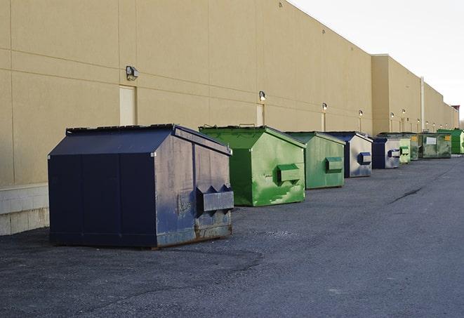 construction workers toss wood scraps into a dumpster in Emlyn